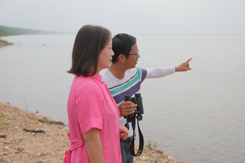 自愿者徐建利（右），，，，，向王琼解说江豚拍摄点位和寓目角度。。。h49a1727.jpg